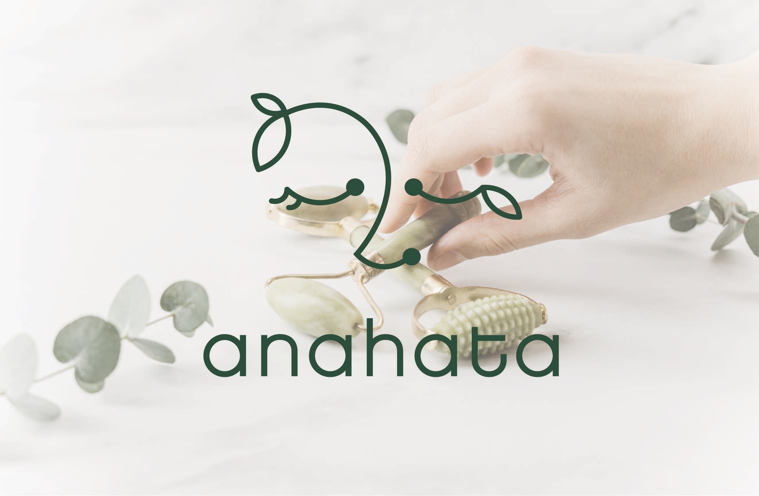Anahata logo and jade facial roller on a marble surface