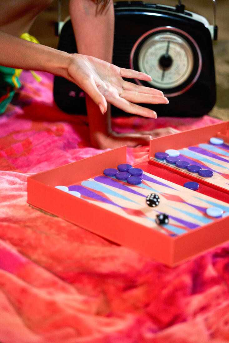 Guests playing backgammon on a red blanket at Belek Beach Resort