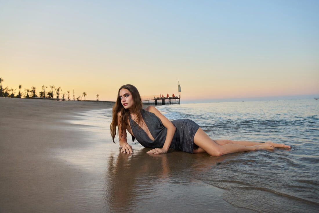Guest lying on the beach shore at sunset at Belek Beach Resort