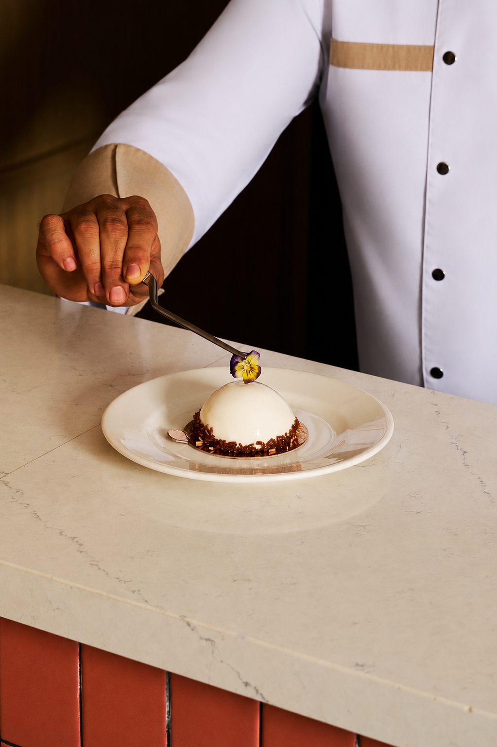 Chef plating a dessert at the table