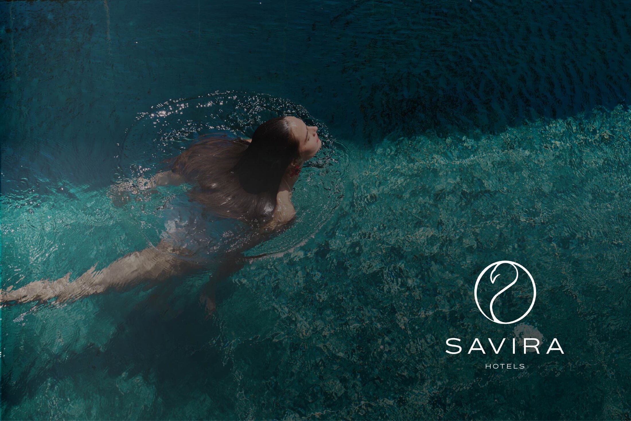 A swimmer in turquoise water beside the finished Savira Hotels flamingo mark