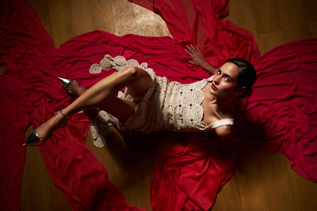 Guest reclining on red fabric in an evening dress at Belek Beach Resort